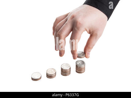 Stapel von Münzen und die menschliche Hand auf weißem Hintergrund Stockfoto