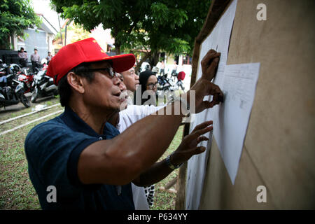 Bekasi, Indonesien. 27 Juni, 2018. Einige Bewohner wurden auch mit Blick auf die Liste der Wahllokale (TPS) Standorten in Bekasi, West Java, Mittwoch verfügbar (27/06/2018). Credit: kuncoro Widyo Rumpoko/Pacific Press/Alamy leben Nachrichten Stockfoto
