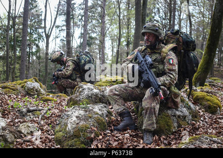 Italienische Soldaten der 5. Regiment 187. Fallschirmjäger-Regiment "Folgore" nehmen eine taktische Pause während einer Bewegung, Szenario während des Trainings Saber Junction 16 an der US-Armee gemeinsamen multinationalen Readiness Center (JMRC) in Hohenfels, Deutschland, 13. April 2016 zu kontaktieren. Säbel Junction 16 ist der US-Army Europe 173rd Airborne Brigade Kampftraining Zentrum Zertifizierung Übung stattfindenden JMRC in Hohenfels, Deutschland, Mrz 31-Apr 24, 2016.  Die Übung soll die Bereitschaft der Armee Europa ansässigen Kampfbrigaden zu einheitlichen Land-Operationen durchzuführen und zu fördern Intero bewerten Stockfoto