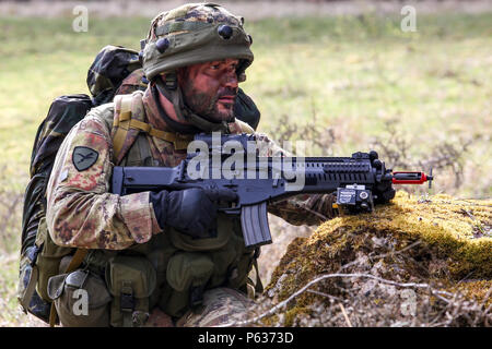 Ein italienischer Soldat des 5. Regiment 187. Fallschirmjäger-Regiment "Folgore" sorgt für Sicherheit während einer Bewegung, Szenario während des Trainings Saber Junction 16 an der US-Armee gemeinsamen multinationalen Readiness Center (JMRC) in Hohenfels, Deutschland, 13. April 2016 zu kontaktieren. Säbel Junction 16 ist der US-Army Europe 173rd Airborne Brigade Kampftraining Zentrum Zertifizierung Übung stattfindenden JMRC in Hohenfels, Deutschland, Mrz 31-Apr 24, 2016.  Die Übung soll die Bereitschaft der Armee Europa-basierten Kampfsystem bewerten interope Brigaden zu einheitlichen Land-Operationen durchzuführen und zu fördern Stockfoto