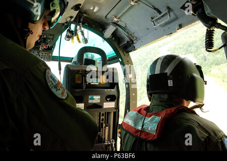 Ein Coast Guard Air Station Houston helicopter Aircrew blickt von einem MH-65 Dolphin Helikopter bei einem Überflug der Bewertung und der Suche nach Personen in Not nach den jüngsten Überschwemmungen im Südosten von Texas, 19. April 2016. Ein Coast Guard Station Houston 29-Fuß-antwort Crew, zusammen mit zwei Boot Besatzungen von der Küstenwache Aids zur Navigation Team Galveston eingerichtet Post in Humble, Texas, um die Lokalen Not Operating Center Antwort bemühen zu unterstützen. U.S. Coast Guard Foto von Petty Officer 3. Klasse Jennifer Nease. Stockfoto