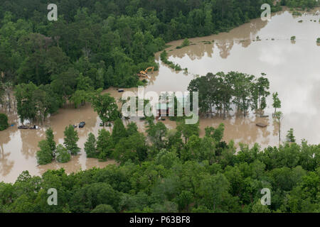 Ein Coast Guard Air Station Houston helicopter Aircrew blickt von einem MH-65 Dolphin Helikopter bei einem Überflug der Bewertung und der Suche nach Personen in Not nach den jüngsten Überschwemmungen im Südosten von Texas, 19. April 2016. Ein Coast Guard Station Houston 29-Fuß-antwort Crew, zusammen mit zwei Boot Besatzungen von der Küstenwache Aids zur Navigation Team Galveston eingerichtet Post in Humble, Texas, um die Lokalen Not Operating Center Antwort bemühen zu unterstützen. U.S. Coast Guard Foto von Petty Officer 3. Klasse Jennifer Nease. Stockfoto