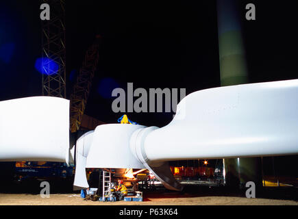 Lange Belichtung geschossen in der Nacht für einen Arbeitnehmer, der Montage der Nabe und Rotorblätter eines riesigen ENERCON Windenergieanlage in Vorbereitung für die Montage vor Ort. Worksop Uni Stockfoto