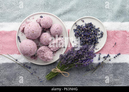 Handgefertigte Lavendel Bad Bomben und Blumen auf dem Handtuch Stockfoto