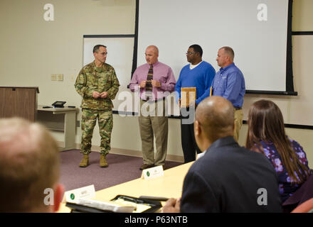 Oberst Brett Funck, Fort Bragg Garrison Commander, stellt Tony Jones, US Army Forces Command/USA Army Reserve Command Gebäude Manager (links), Ricky Bell (Mitte) und Bobby Warren (rechts), Facility Engineering Techniker, mit dem "Grünen Boot Program Award" an der Fort Bragg Abteilung für Öffentliche Arbeiten Hauptquartier, 13. April 2016. Das grüne Boot-Programm ist eine Chance für die Agenturen auf Post ihre Missionen durch Umgang mit Ressourcen zu verbessern, mit dem Ziel der Reduzierung von Umweltauswirkungen einer Anlage oder der Direktion, Neuzuweisung der Mittel gespeichert. Durch Initiativen wie Wasser Stockfoto