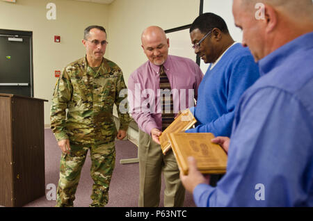 Oberst Brett Funck, Fort Bragg Garrison Commander, stellt Tony Jones, US Army Forces Command/USA Army Reserve Command Gebäude Manager (links), Ricky Bell (Mitte) und Bobby Warren (rechts), Facility Engineering Techniker, mit dem "Grünen Boot Program Award" an der Fort Bragg Abteilung für Öffentliche Arbeiten Hauptquartier, 13. April 2016. Das grüne Boot-Programm ist eine Chance für die Agenturen auf Post ihre Missionen durch Umgang mit Ressourcen zu verbessern, mit dem Ziel der Reduzierung von Umweltauswirkungen einer Anlage oder der Direktion, Neuzuweisung der Mittel gespeichert. Durch Initiativen wie Wasser Stockfoto