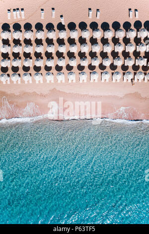 Luftaufnahme von unglaublichen türkisfarbenen Meer mit weißen Sonnenschirme und Liegestühle. Schönen sonnigen Sommertag in Sardinien, Mittelmeer, Italien. Stockfoto