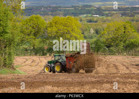 Ein Bauer mit einem dungstreuer hinter seinem Traktor eine organische  Mischung von Dnger und Heu auf seinem Grundstck fr die Befruchtung zu  verbreiten Stockfotografie - Alamy