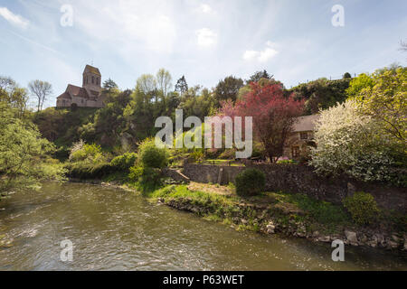 Saint-Ceneri-le-Gerei, Normandie Frankreich. Der Fluss Sarthe in einer waldreichen Umgebung mit der alten Kirche im Hintergrund. Stockfoto