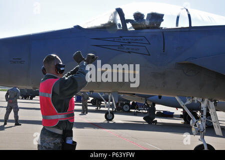 Us Air Force und Massachusetts Air National Guard Waffen laden chief Signale der Pilot einer F-15C Eagle zu bremsen, so dass die Waffen des Flugzeugs für Frisian Flag 2016, Leeuwarden, Niederlande, 21. April 2016 scharfgeschaltet werden können. Die Übung dauert von April 11-22 und besteht aus mehr als 70 Flugzeuge und mehrere hundert Mitarbeiter aus den Vereinigten Staaten, den Niederlanden, Belgien, Frankreich, Finnland, Polen, Norwegen, Großbritannien, Deutschland und Australien. Stockfoto