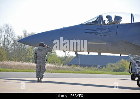 Us Air Force und Massachusetts Air National Guard Crew Chief begrüßt F-15C Eagle Pilot, als er sich auf eine Mission während Frisian Flag 2016 begibt. Der Royal Netherlands Air Force Übung sollen zur Förderung der militärischen Zusammenarbeit zwischen den teilnehmenden Nationen und diese Art von Austausch die Vertrauen und Beziehungen aufzubauen, 21. April 2016. Stockfoto