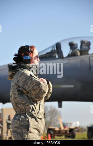 Us Air Force und Massachusetts Air National Guard Flieger 1. Klasse Sarah Stec Signale der Pilot einer F-15C Eagle Flugzeuge zu halten und die Taxi wie andere F-15C von Taxis, 21. April 2016 warten. Airman 1st Class Stec in Leeuwarden, Niederlande bereitgestellt, mit der uad-2 Expeditionary Fighter Squadron und ist derzeit die Beteiligung an der Frisian Flag 2016 ausüben. Die Übung dauert von April 11-22 und besteht aus mehr als 70 Flugzeuge und mehrere hundert Mitarbeiter aus den Vereinigten Staaten, den Niederlanden, Belgien, Frankreich, Finnland, Polen, Norwegen, das Vereinigte Königreich, Deutschland und Australien Stockfoto