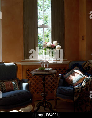 Blauen Sesseln und kleinen antiken Tisch vor der Fenster mit grün gestrichenen Fensterläden Stockfoto