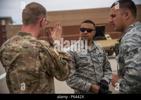 Armee Sgt. Bryant Schneegass, 152 Bewegung Control Team Bewegung noncommissioned Officer bei Fort Carson, Colo stationiert, spricht über die Durchführung einer gemeinsamen Prüfung auf Cargo Air Force Staff Sgt. Erik Brunson und Senior Airman Jake Saville, Antenne Torhüter der 821St Contingency Response Geschwader zugewiesen bei Travis Air Force Base, Calif., während Cerberus Streik 16-01 in Fort Carson, 23. April 2016 stationiert. Eine gemeinsame Kontrolle ist von Ladung und Fahrzeugen, die auf Flugzeuge geladen ist erforderlich. (U.S. Air Force Foto von Tech. Sgt. Gustavo González/Freigegeben) Stockfoto