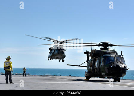 Australische Royal Navy führenden Seamans Timu und Harrison arbeiten auf dem Flugdeck mit MRH90 und CH-53-Hubschrauber während der Übung Sea Explorer an Bord der HMAS Canberra auf See Juni 9, 2018. Die Hubschrauber und Soldaten üben Rescue & Recovery Missionen als Teil der gesamten Ex Meer Serie 18. Die Serie wurde entwickelt, um australischen Streitkräfte auszubilden und ihnen amphibische fertig zu werden. Us-Marines und Matrosen mit Marine Drehkraft - Darwin 18 in Zusammenarbeit mit der Australian Defence Force sind als Teil des Amphibious Task Group. (U.S. Marine Corps Foto: Staff Sgt. Daniel Wetzel) Stockfoto