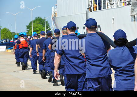 Coast Guard Cutter Tampa Crew Mitglieder tragen einen Landanschluss Kabel an der Pier an der Basis Portsmouth, Virginia, 27. April 2016. Tampa Crew nach Hause zurückgekehrt, nach einem 54-tägigen Fischerei Patrouille. (U.S. Coast Guard Foto von Petty Officer 1st Class Melissa Leake) Stockfoto