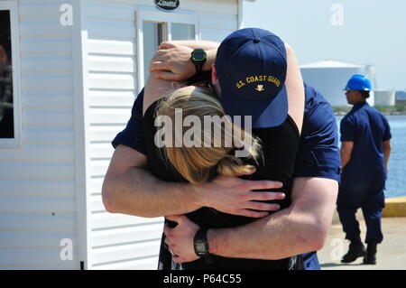 Ein Patrouillenboot Tampa Besatzungsmitglied umarmt seine Frau auf dem Pier an der Basis Portsmouth, Virginia, 27. April 2016. Tampa Crew nach Hause zurückgekehrt, nach einem 54-tägigen Fischerei Patrouille. (U.S. Coast Guard Foto von Petty Officer 1st Class Melissa Leake) Stockfoto