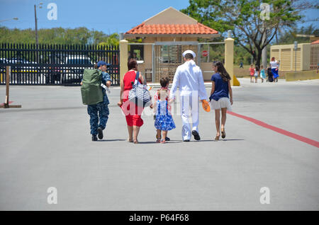 160411-N-DA 434-112 Santa Rita, Guam (11. April 2016) der Maschinist Mate 1. Klasse Kevin Livingston, zum U-Boot Tender USS Emory S. Land zugewiesen (39), geht weg von Sierra Pier mit seiner Familie nach der Rückkehr von einem sechsmonatigen Einsatz. Die Rückkehr nach Guam ist Emory S. Land's erste seit dem Wechsel von homeport von Diego Garcia nach Guam, Dez. 23. Emory S. Land ist ein EXPEDITIONARY U-Boot Ausschreibung Durchführung von koordinierten neigten, Liegeplätze und flott Wartung in den USA 5. und 7 Flotte Bereiche. (U.S. Marine Foto von Massenkommunikation Seaman Apprentice Alana Langdon/Freigegeben) Stockfoto