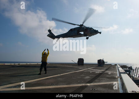 {Filename base} Golf von Aden (11. April 2016) der Luftfahrt Bootsmann Mate (Handling) Seemann Robert Doane Signale einem MH-60 Knight Hawk aus der "Wild Cards" der Hubschrauber Meer bekämpfen (HSC) Squadron 23 weg von der Flight Deck nachdem Sie Speicher während einer vertikalen Replenishment (VERTREP) an Bord amphibious Transport dock Schiff USS New Orleans LPD (18). USS New Orleans ist Teil der Boxer amphibische Gruppe und bereit, mit der begonnen 13 Marine Expeditionary Unit, ist auf die Unterstützung der Maritime Security Operations und Theater Sicherheit Zusammenarbeit im Bereich der Fünften Flotte Betrieb bereitgestellt Stockfoto