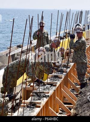 160425-N-HU 290-243 Yokosuka, Japan (Apr. 25, 2016) - seabees zu Naval Mobile Konstruktion Bataillon (NMCB) 4, füllen Schalung mit Beton entlang der Bucht von Tokio in Yokosuka, Japan zugeordnet. NMCB 4 ist der Vorwärts bereitgestellt Pacific NMCB bereit, größeren Kampfhandlungen zu unterstützen, humanitäre Hilfe/Disaster relief Operations und General Engineering Support zum Navy, Marine Corps und gemeinsamer operativer Kräfte zur Verfügung stellen. (U.S. Marine Foto von Bau Elektriker 3. Klasse Christopher Evenson/Freigegeben) Stockfoto