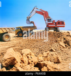 Bagger und Dumper vor Ort. Bagger laden dumptrucks am Flughafen Athen Ort, Spata, Griechenland. Stockfoto