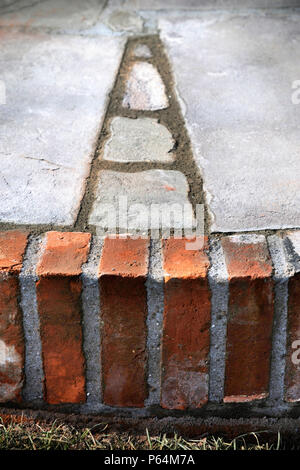 Kürzlich sagte ein Austrocknen der Gelenke auf einer Terrasse mit Natursteinplatten verlegt und aufgearbeitete rote Ziegelsteine, Großbritannien Stockfoto