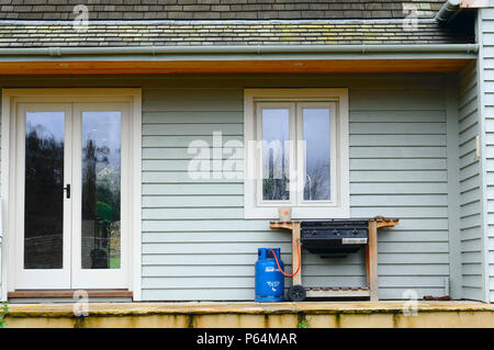 Ein Gas Grill mit Holz verkleidete Haus Gloucestershire, Großbritannien Stockfoto