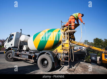 Eine konkrete Lieferung Mann wäscht heraus die Rutsche nach dem Gießen ein Mix aus Beton. Die Zementindustrie ist EINEDER die Carbon hungrig auf dem Planeten. Stockfoto