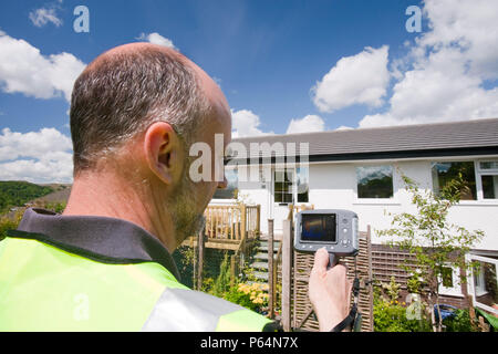 Ein Techniker anhand eine Wärmebildkamera Wärmeverlust aus einem Haus geprüft. Stockfoto