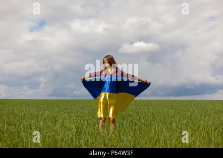 Junge schöne ukrainische Mädchen mit eine ausgezeichnete Figur in kurze Jeans Shorts hält einen Nationalen Ukrainischen gelb Blaue Flagge im Wind wieder Stockfoto