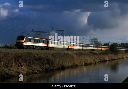Eine Klasse 90 elektrische Leiter einer northbound West Coast Main Line Service im InterCity livery neben der Oxford Canal an Anstey. Februar 1998 Stockfoto