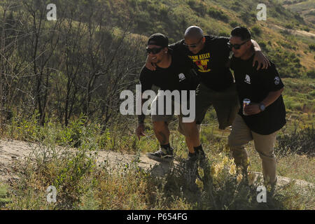 Us Marine Corps veteran Cpl. Josue Barron, Mitte rechts, 3.BATAILLON, 5. Marine Regiment (3/5), ist beim Wandern bis ersten Sergeants Hill während der Teilnahme an einer Gedenkfeier für die Schlacht von sangin auf die Marine Corps Base Camp Pendleton, Calif., 29. April 2016 geholfen. Während der Schlacht von Sangin in 2010, 3/5 erlitten schwere Verluste in dem, was als die blutigste Schlacht Boden Afghanistans. (U.S. Marine Corps Combat Kamera Foto von Lance Cpl. Sergio RamirezRomero/Freigegeben) Stockfoto