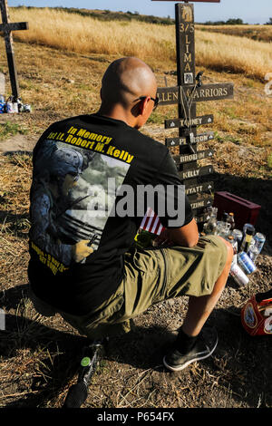 Us Marine Corps veteran Cpl. Josue Barron, 3rd Battalion, 5th Marine Regiment (3/5), kniet neben einem Kreuz auf ersten Sergeants Hill während der Teilnahme an einer Gedenkfeier für die Schlacht von sangin auf die Marine Corps Base Camp Pendleton, Calif., 29. April 2016. Während der Schlacht von Sangin in 2010, 3/5 erlitten schwere Verluste in dem, was als die blutigste Schlacht Boden Afghanistans. (U.S. Marine Corps Combat Kamera Foto von Lance Cpl. Sergio RamirezRomero/Freigegeben) Stockfoto