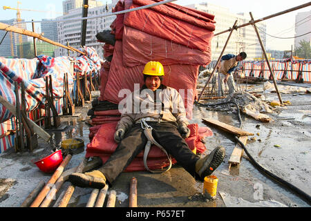 Eine chinesische Migranten Arbeiter nimmt eine Pause während den Bau einer Hochstraße in Peking. Stockfoto