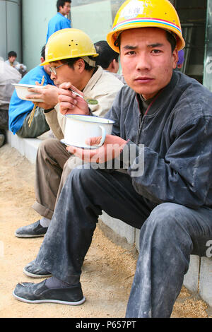 Bauarbeiter beim Mittagessen vor Ort in Peking. Stockfoto