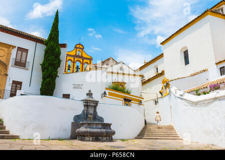 Andalusien Spanien Stadt, eine Frau geht durch einen Abschnitt der Altstadt von Cordoba mit typischen weißen andalusischen Gebäude, Andalusien, Spanien. Stockfoto