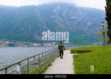 Männliche touristische Wanderungen in Bannister, den Comer See und Alpen Berg im Hintergrund. Stockfoto