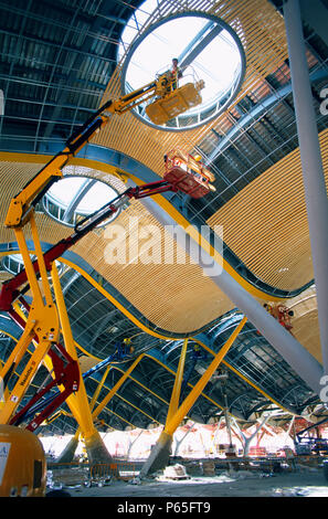 Access Plattform. Arbeiter auf einem Cherry Picker. Arbeiten von Wartezonen auf der Bambus Innenverkleidung für die Decke der Halle an Stockfoto