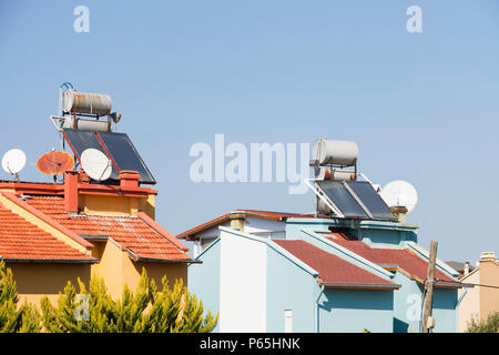 Solare Wasser-Heizungen auf Häuserdächern in Teos, Türkei. Stockfoto