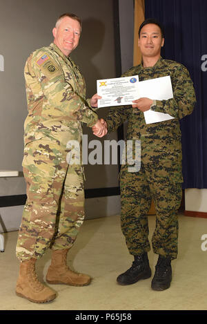 Us-Armee Oberstleutnant Douglas Hayes, Commander, 1st Battalion, 82nd Field Artillery Regiment, 1st Armored Brigade Combat Team, 1.Kavallerie Division, gratuliert Ehre Absolvent Republik Korea Armee Kapitän Bum seok Lee 28. April im Camp Hovey Theater. Lee war die Ehre Absolvent für die erste Gemeinsame Brände Militärbeobachterlehrgang mit Südkoreanischen und amerikanischen Soldaten statt. (U.S. Armee Foto von Sgt. Christopher Dennis, 1st Armored Brigade Combat Team Public Affairs, 1. Cav. Div.) Stockfoto