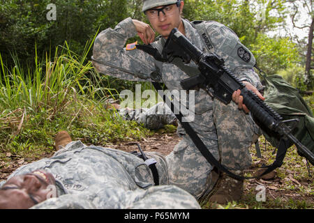 JOINT BASE Pearl Harbor - HICKAM, Hawaii - USA Armee SPC Zuleima Garcia, ein Eingeborener von Oakdale, Calif. und eine Luftverteidigung early warning system Operator erweitert, mit Hauptsitz und Sitz, 1. Batterie Bataillon, 1 Air Defense Artillery Regiment, 94th Army Air und Raketenabwehr Befehl, bietet Pflege unter Feuer zu einem simulierten Unfall, 26. April 2016, während der Krieger Aufgabe Prüfung Teil der 94th AAMDC Soldat des Jahres 2016 Schofield Barracks Osten, Hawaii. Stockfoto