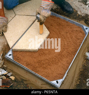 Installation eines Kanaldeckel über das Ablassen. Stockfoto