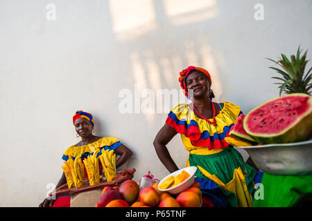 Afro-Frauen, in der traditionelle "palenquera' Kostüm, verkaufen Obst auf der Straße von Cartagena, Kolumbien. Stockfoto