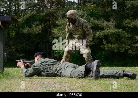 Ein US-Soldat, der 173rd Airborne Brigade zugewiesen beobachtet ein polnischer Soldat, 34. Rüstung-Kavallerie-Brigade zugewiesen, wie er ein PM-84 Glauberyt, als Teil von der starken Europa Tank Herausforderung (SETC) bei der 7. Armee gemeinsame multinationale Ausbildung des Befehls Grafenwöhr Training Area, Grafenwöhr, Deutschland, 10. Mai 2016 feuert. Der SETC ist von US-Army in Europa und die deutsche Bundeswehr, 10.-13. Mai 2016 Co-Gastgeber. Der Wettbewerb soll militärische Partnerschaft zu fördern, während NATO Interoperabilität zu fördern. Sieben Züge aus sechs NATO-Staaten treten SETC - die erste multinationale tan Stockfoto