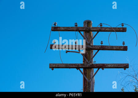 Eine alte und verfallene, getrennt für die Stromversorgung Pol in Land NSW, Australien mit baumelnden Kabel Stockfoto