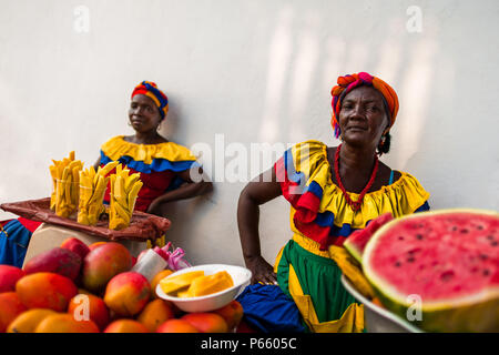 Afro-Frauen, in der traditionelle "palenquera' Kostüm, verkaufen Obst auf der Straße von Cartagena, Kolumbien. Stockfoto