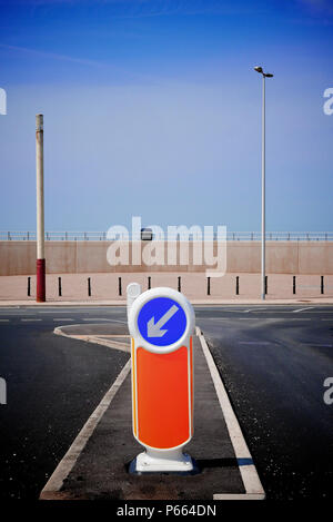 Links sign an Kreuzung halten vor der Betonwand, Cleveleys, Großbritannien Stockfoto