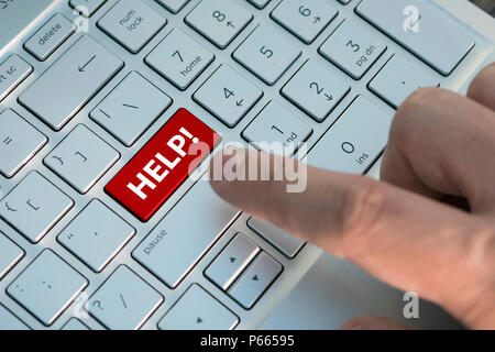 Rote Schaltfläche Hilfe auf der Tastatur close-up einen männlichen Finger drückt eine Taste Farbe Grau Silber Tastatur eines modernen Laptop. Taste mit Beschriftung cl Stockfoto