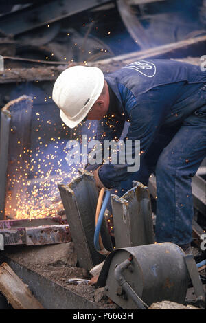 Arbeiter mit Gasbrenner Altmetall zu schneiden. Stockfoto