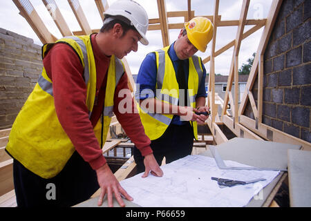 Bauarbeiter, die Pläne vor Ort zu überprüfen. Stockfoto